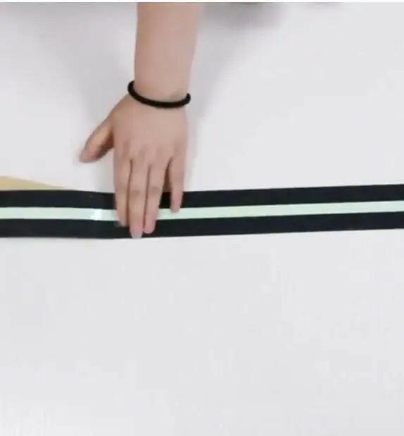 Hand applying anti slip glow tape on a surface for improved safety and visibility