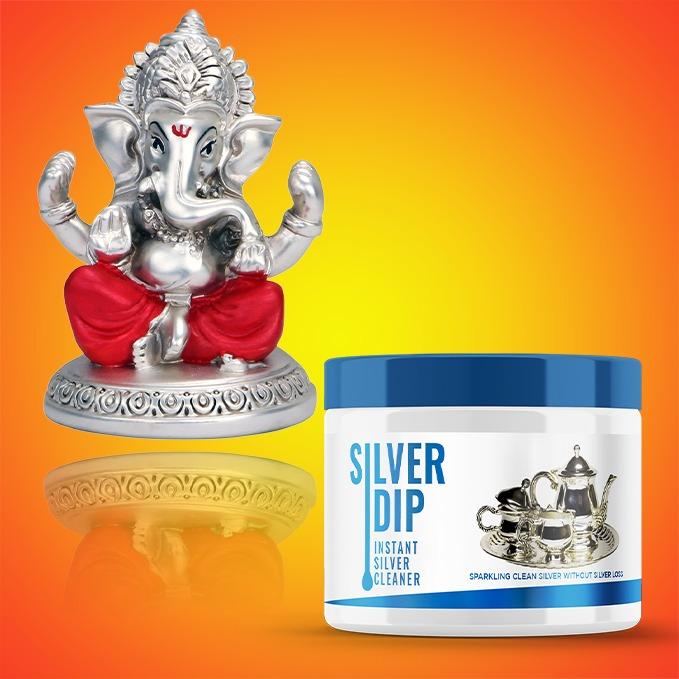 Instant silver cleaner with a container and a silver Ganesh statue on a vibrant orange background
