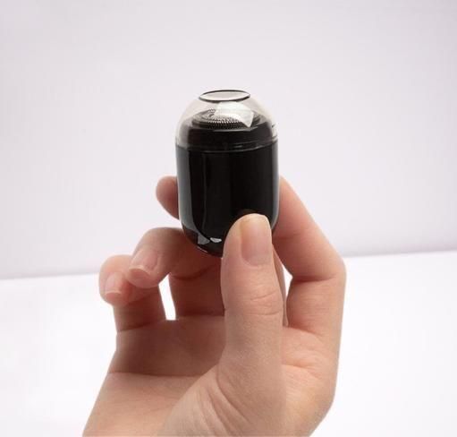 Compact electric shaving machine held in hand, perfect for travel and quick touch-ups